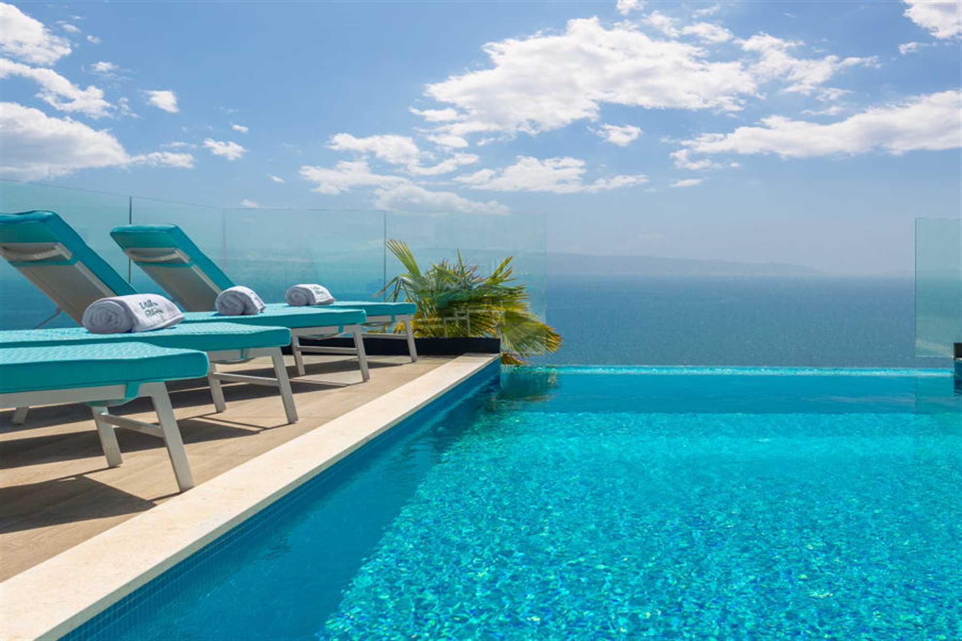 Beautiful sea view from pool terrace equipped with deck chairs